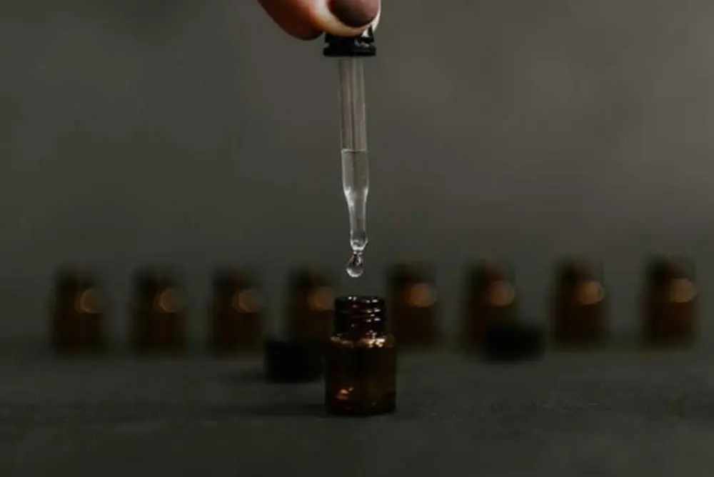 Essential oil being extracted from vial with dropper