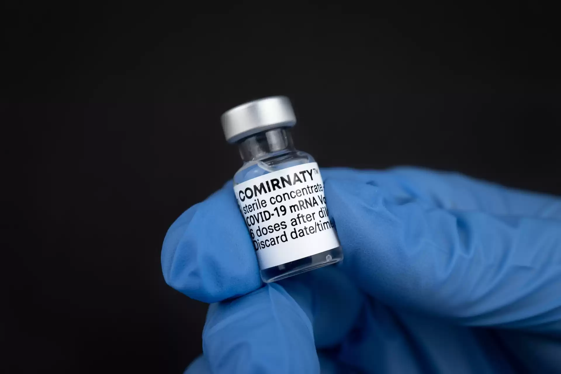 A small vial containing the COVID-19 vaccine